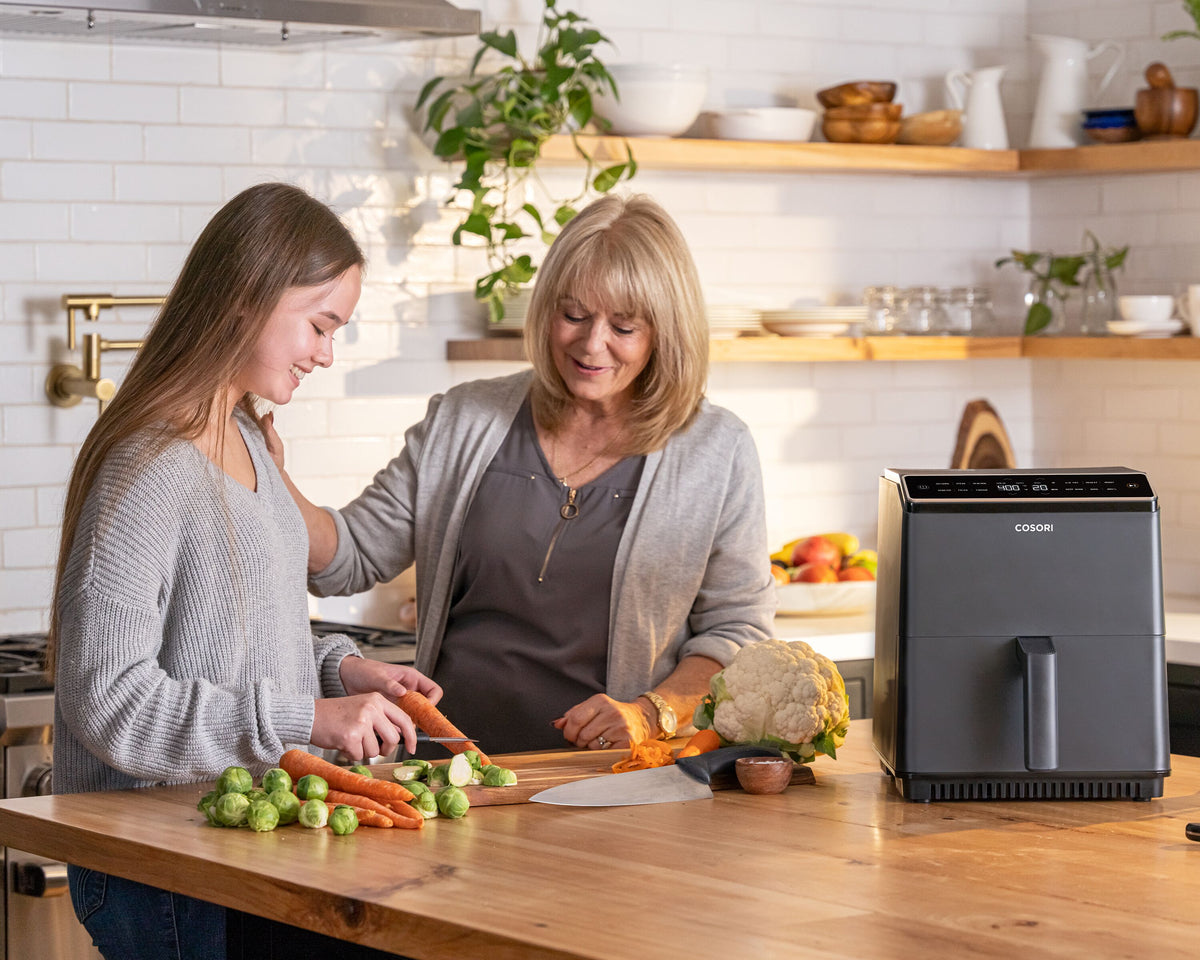 grandma and granddaughter cooking with an air fryer