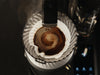 Pour-over coffee dripper with bloomed grounds, showing the coffee brewing process