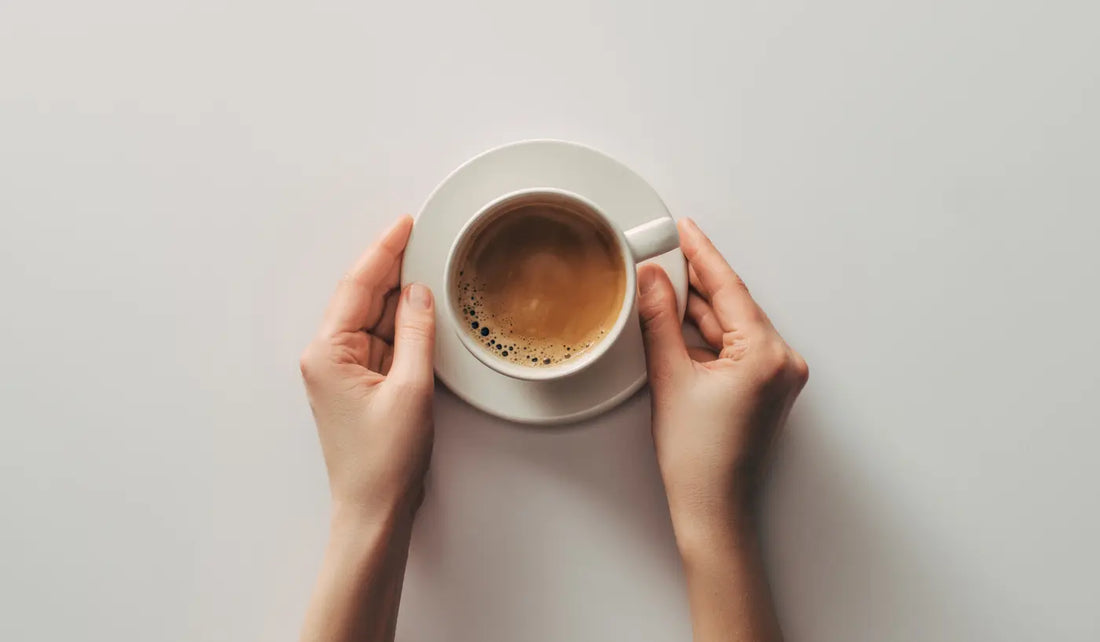 Hands holding a cup of freshly brewed coffee, representing everyday home coffee brewing