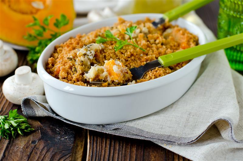 Chicken wild rice casserole with a golden crumb topping in a white dish with green spoons