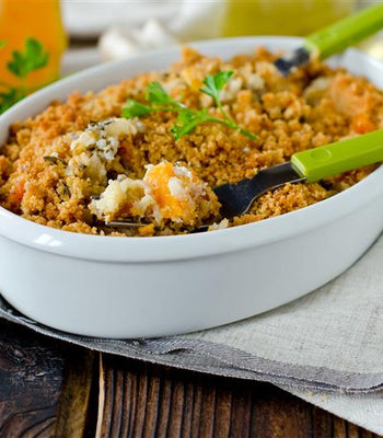 Chicken wild rice casserole with a golden crumb topping in a white dish with green spoons