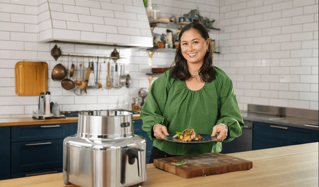 Food content creator Corre Larkin smiling and holding a beautifully plated dish in her kitchen, with the Cosori Iconic air fryer