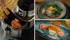 A Cosori air fryer cooking steak next to gourmet plated dishes of salmon and tofu with vegetables.