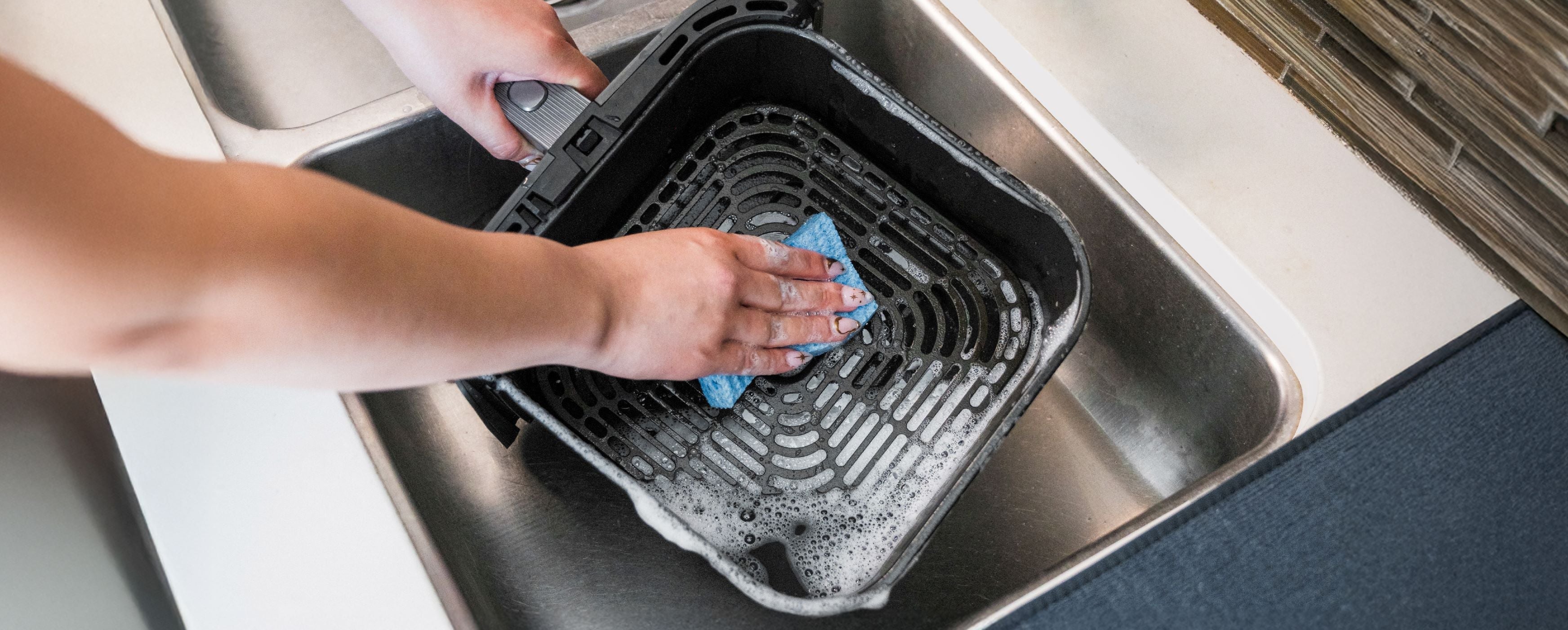 Cosori air fryer on kitchen counter showing cleaning and maintenance setup