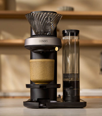 A Cosori Juni automated pour-over coffee maker standing on a kitchen countertop.