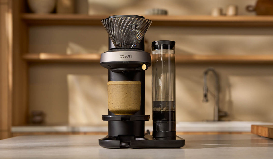 A Cosori Juni automated pour-over coffee maker standing on a kitchen countertop.
