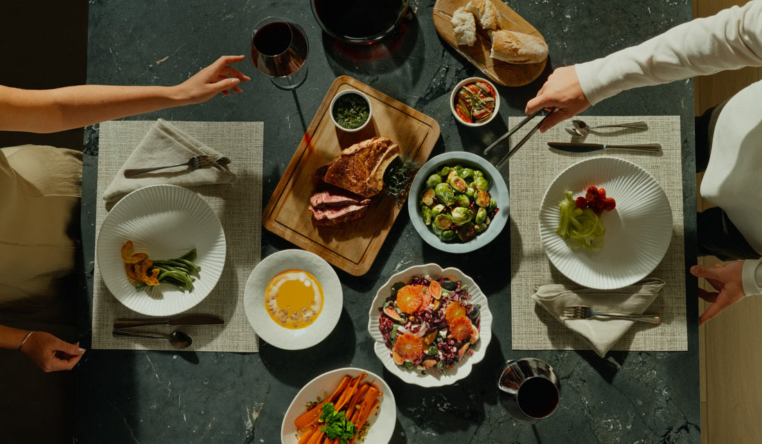 Top-down view of a large dinner spread including steak, roasted vegetables, and salad, perfect for family meals.