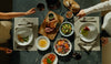 Top-down view of a large dinner spread including steak, roasted vegetables, and salad, perfect for family meals.