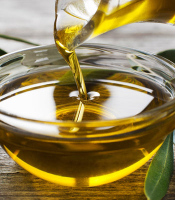 Olive oil being poured into a bowl, representing healthy cooking oils for everyday meals