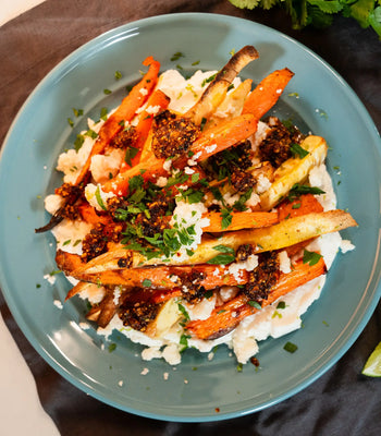 dish of roasted vegetables on yogurt, topped with salsa macha and queso fresco