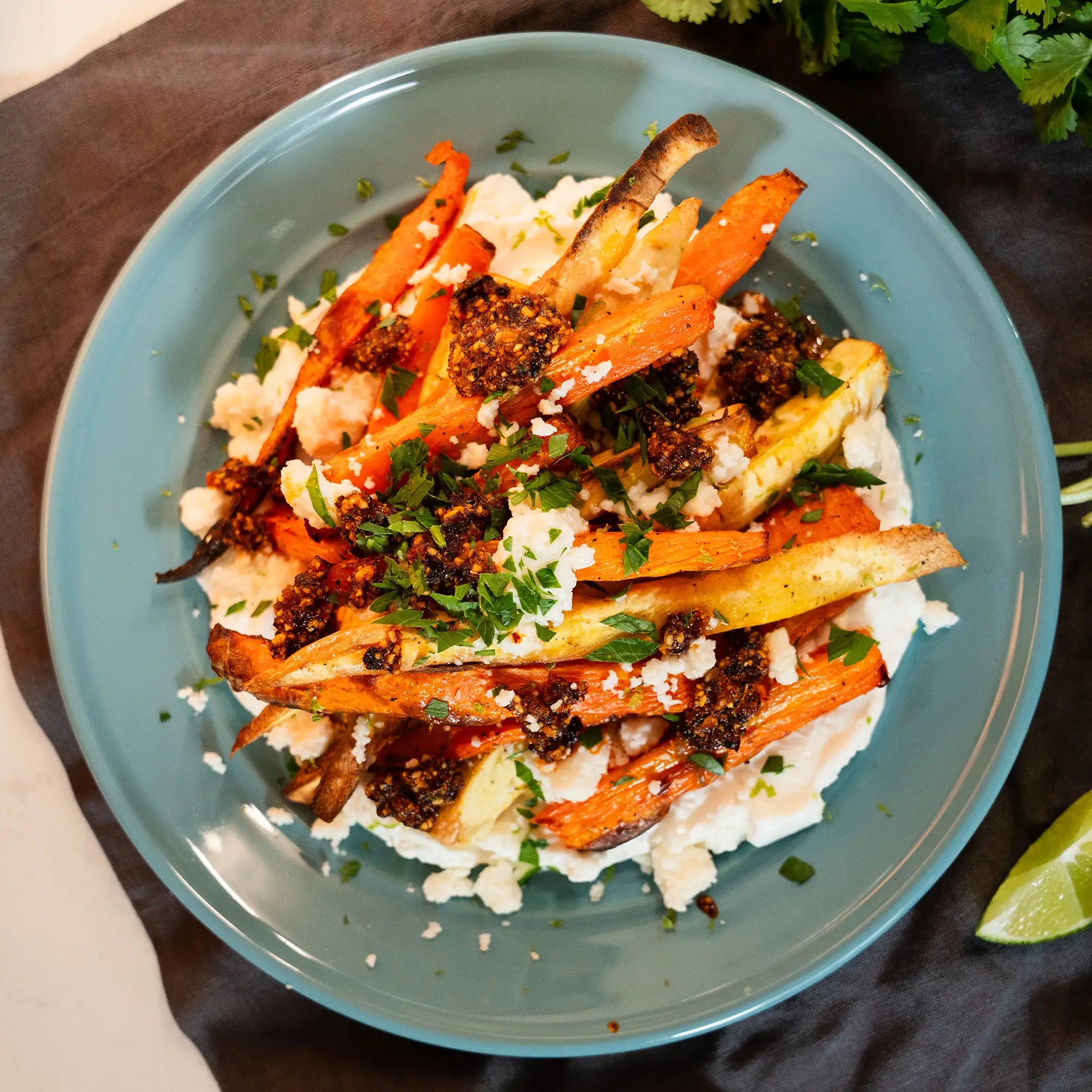 dish of roasted vegetables on yogurt, topped with salsa macha and queso fresco