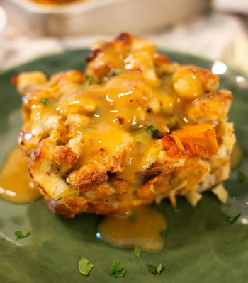 A savory Thanksgiving bread pudding covered in rich, golden-brown gravy
