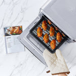 COSORI 13-Quart Air Fryer Oven tray holding cooked chicken wings inside oven