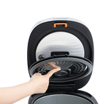Hand demonstrating how to remove the inner lid of the Cosori Rice Cooker with a push button.